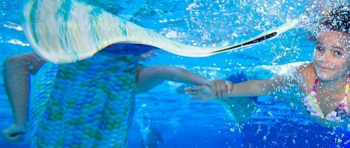 Twee kinderen zwemmen als zeemeermin onder water